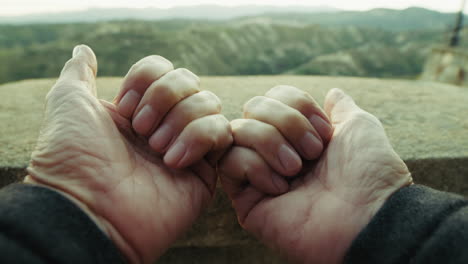 point of view hands of an elderly man touch the balcony and overlooks the nature