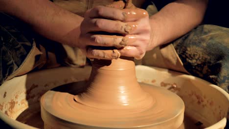 a close view on potters hands throwing a vase.