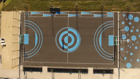 aerial vertical view of a basketball field sunny day. man doing sport