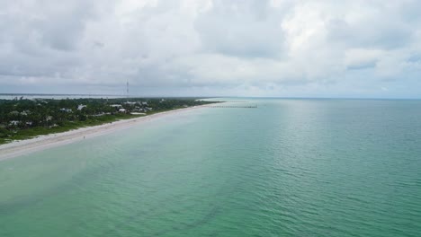 a serene beach in cuyo, mexico, with turquoise waters and cloudy skies, aerial view