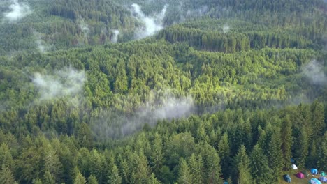 Impressive-Aerial-Drone-Shot-of-the-Romanian-Mountain-Ranges-Pulling-Back-to-Reveal-a-Colorful-Campground