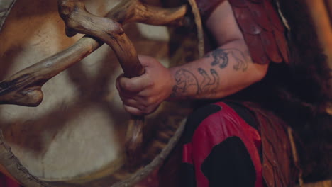 man supports shamanic traditions and plays ritual drum