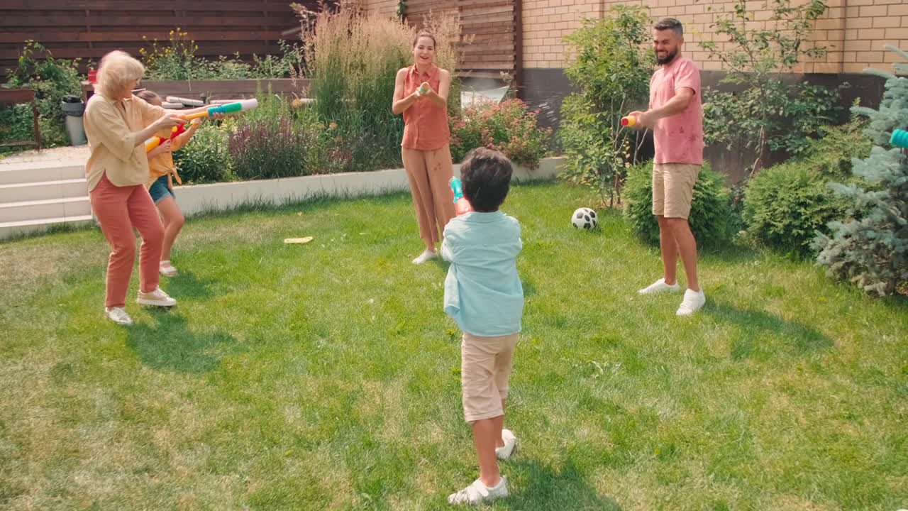 Big Family Splashing Water With Pistols Outdoors