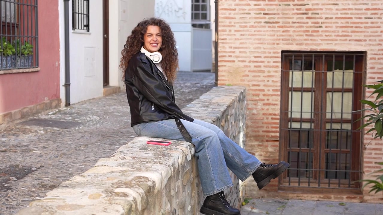 Una donna elegante che si rilassa comodamente in un contesto urbano tra una splendida architettura.