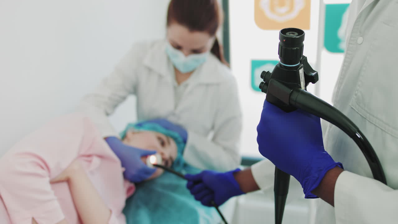 Primo piano delle mani di un medico con guanti protettivi. Un gastroenterologo in uniforme utilizza un joystick