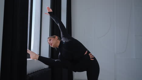 woman doing yoga stretching by the window