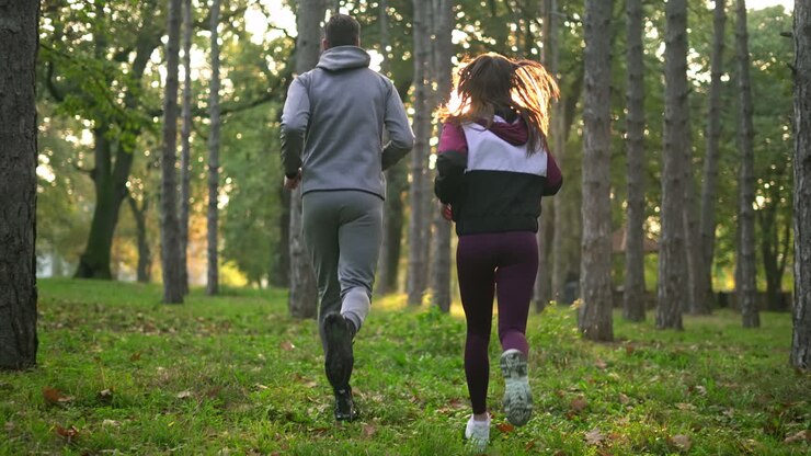 Casal correndo na floresta