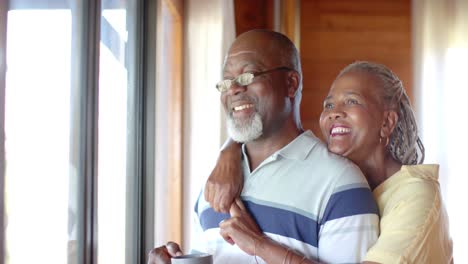 montage of senior african american couple practicing yoga and relaxing at home, slow motion