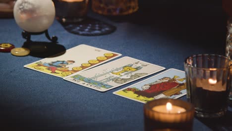 primer plano de una mujer dando una lectura de cartas de tarot en la mesa a la luz de las velas 3