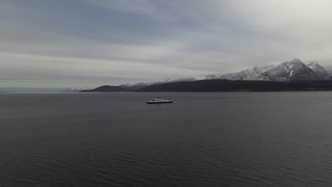 ferry cruising in the arctic ocean, snowy mountains in northern norway