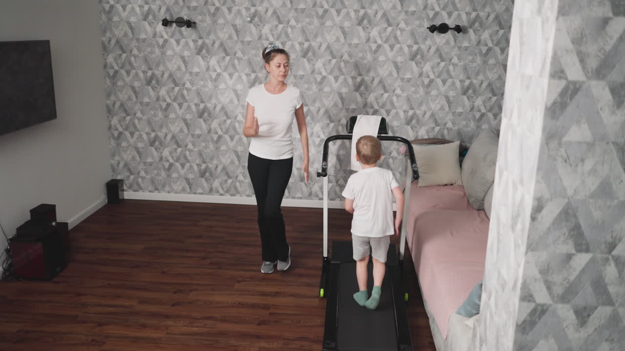 Mother guides young son through engaging workout session as she leads by example in modern living room, promoting family fitness, healthy habits, and parent-child bonding through active routine