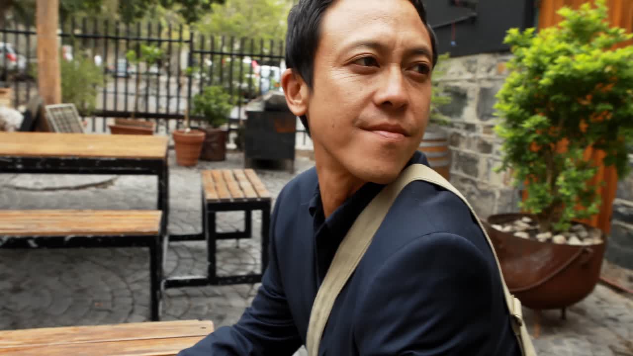 야외 카페 4k에서 벤치에 앉아 사업가