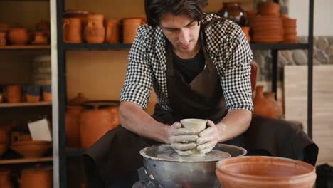 ceramist uses potter's wheel and creates a handmade clay product