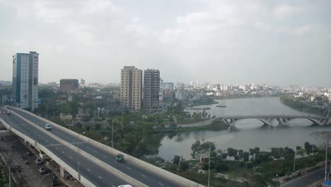 Dhaka-city-beautiful-top-view-pan-shot-left-to-right,-wide-sky-with-city-bridge,-lake,-buildings-and-cars-transportation