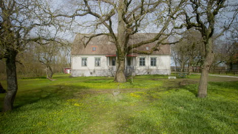 old mansion with a big tree in it's garden in spring time