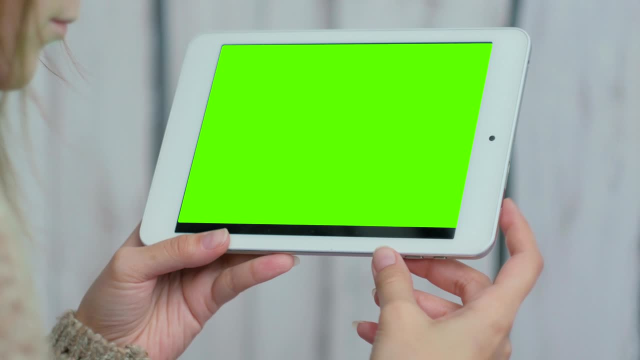 mujer mirando una tableta con pantalla verde