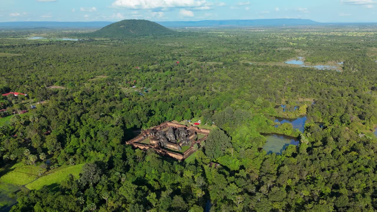 A high-altitude aerial orbit left shows Banteay Samre Temple surrounded by expansive forest and wetlands in the Siem Reap