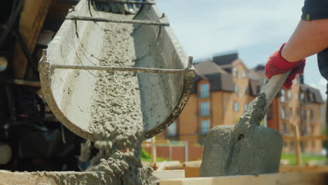 building a cottage workers take concrete from a mixer into a wooden formwork 4k video