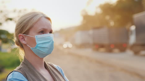 una mujer con una máscara protectora en un camino polvoriento concepto de problemas ecológicos