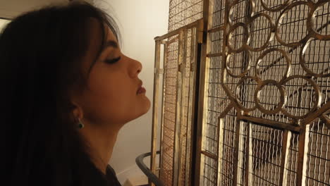 portrait of a beautiful young woman waiting outside an old vintage elevator inside a building in paris, france