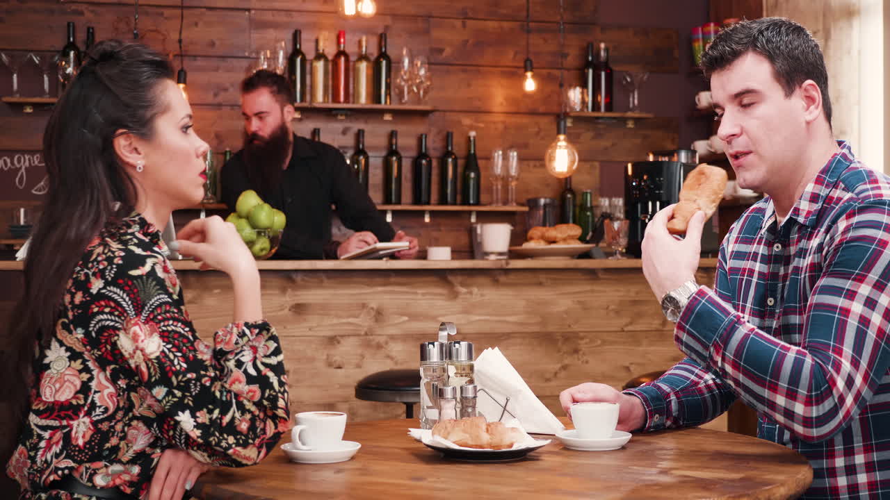 Couple having coffee and croissants in a cozy cafe