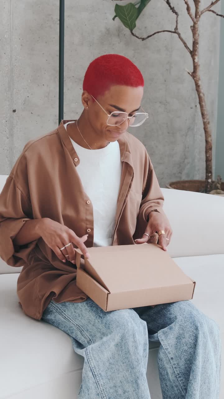 Excitement unfolds as a young woman carefully opens a package at home