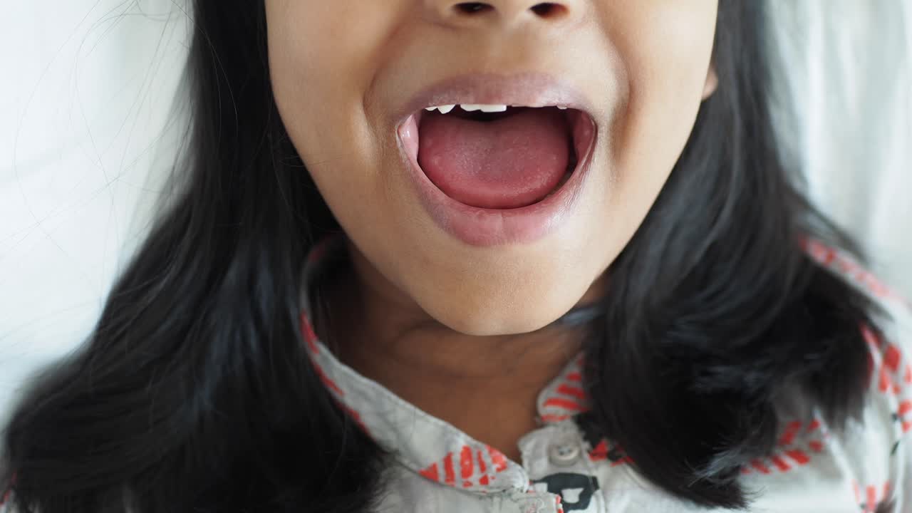 입을 열고 미소 짓는 어린 소녀