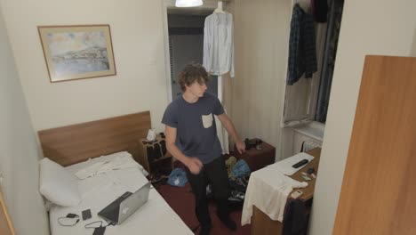 young man dancing in dorm room