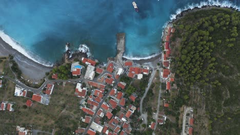 an aerial bird's eye view of a small coastal village in lakonia, greece with a beautiful blue sea