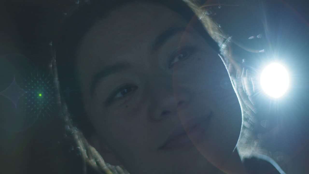 프로젝터 1 의 빛 으로 배경 조명 된 몰입적 인 미술 전시회 를 방문 하고 상호 작용 하는 여성 의 클로즈업