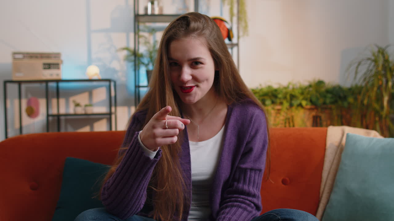 Pretty young woman smiling pointing to camera choosing lucky winner indicating inviting approve