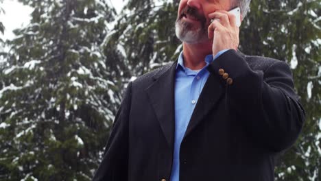 Hombre-Hablando-Por-Teléfono-Y-Cargando-El-Coche-Eléctrico-En-Un-Día-Nevado