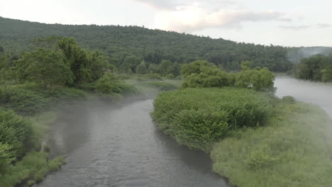 low fly through drone footage over a misty delaware river