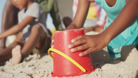 African-american-brother-and-sister-playing-with-sand-on-the-beach