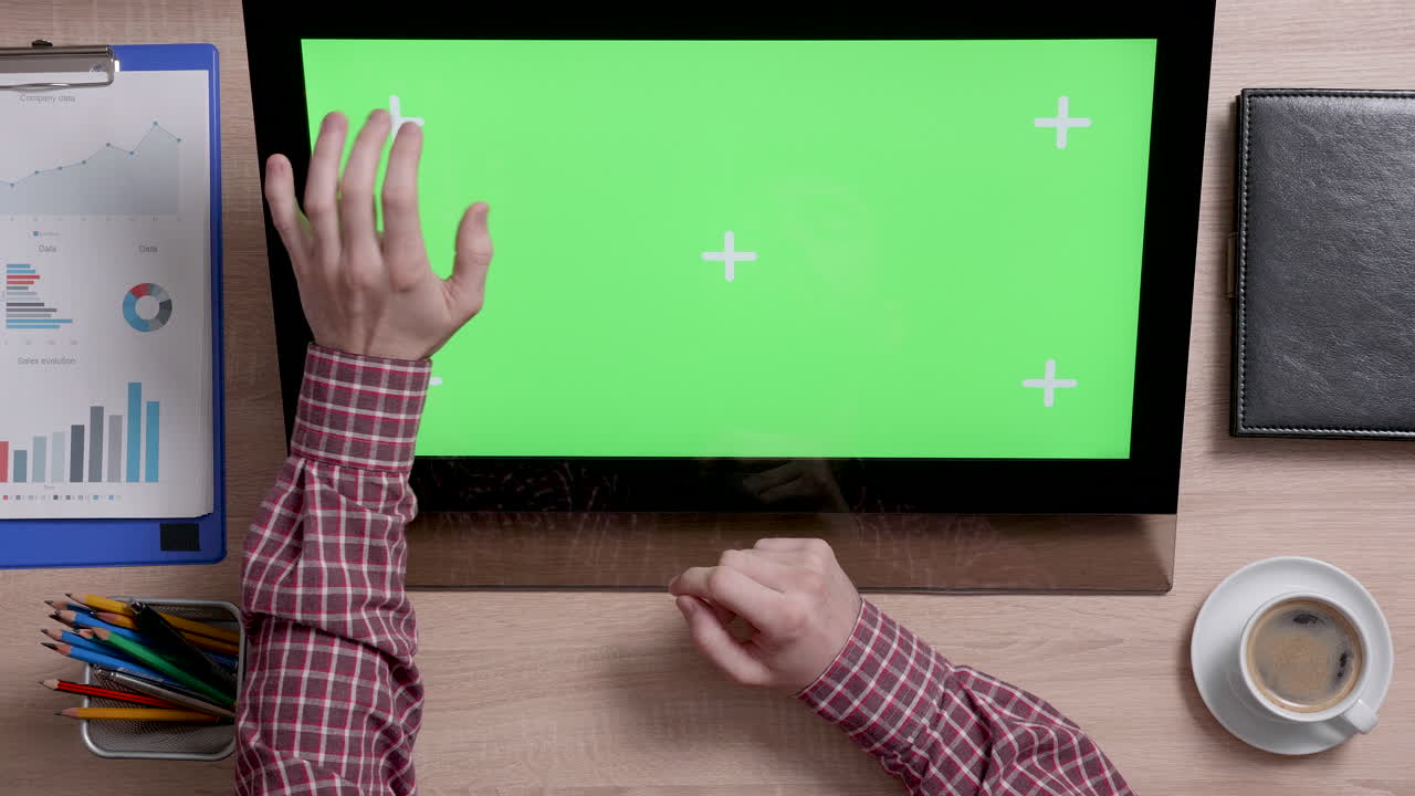 Workstation setup with green screen and business charts