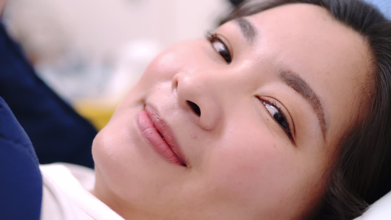 bella mujer sonriendo y mirando a la cámara y encantadora mentira en la cama cubierta con una manta