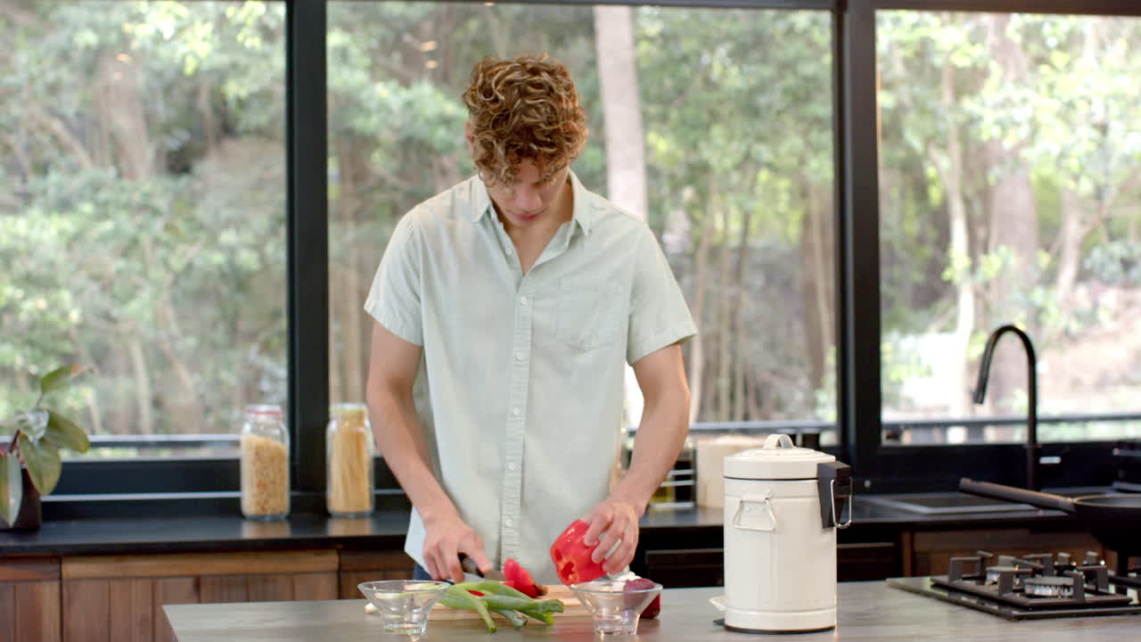 Man chopping vegetables in modern kitchen, preparing meal with fresh ingredients