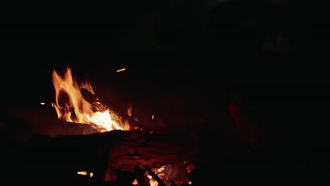 Night-time-fire-with-tent-being-setup-in-the-background