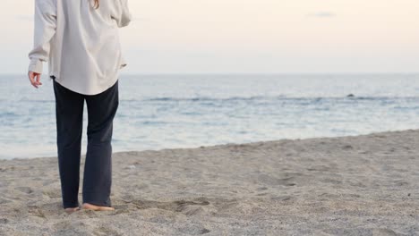 Woman-dancing-chacha-barefoot-on-sand-at-the-seashore-at-sunset-in-Canary-Island,-Tenerife,-static