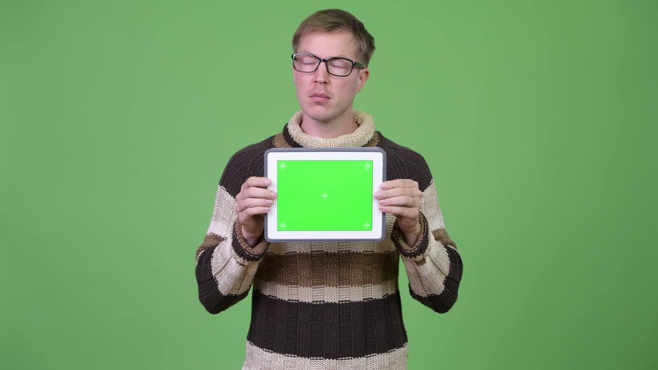 Young handsome man thinking while showing digital tablet