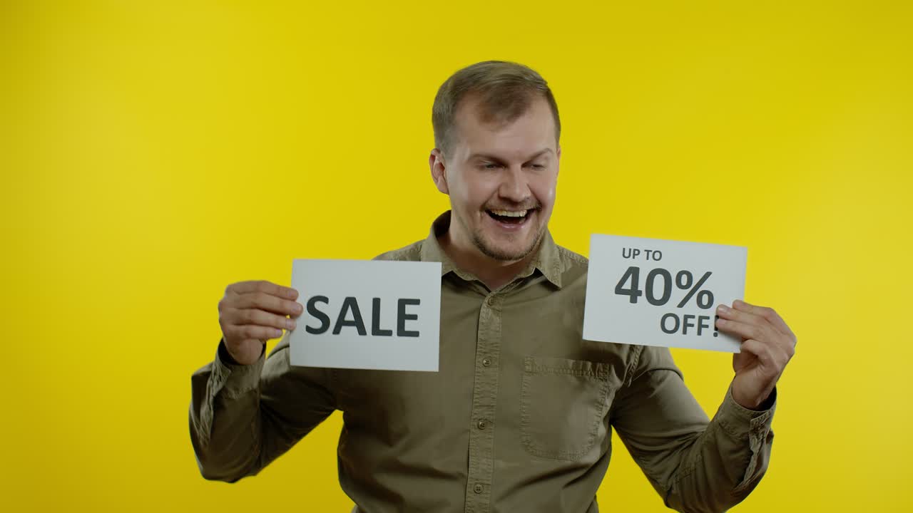 Uomo attraente che mostra la parola Saldi e l'iscrizione Fino al 40% di sconto. Concetto Black Friday
