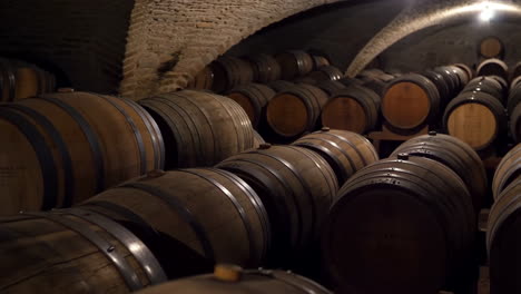 rows of wooden barrels aging in a historic wine cellar