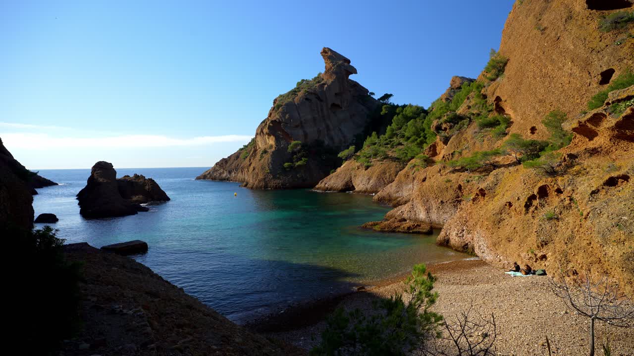 Veduta panoramica di una caletta rocciosa isolata a La Ciotat in Provenza, nel sud della Francia, con acqua di mare mediterranea turchese e cristallina, circondata da aspre scogliere calcaree e una rigogliosa vegetazione verde.