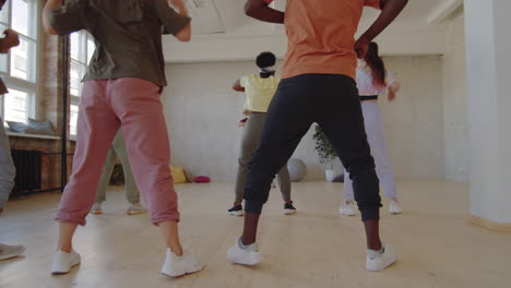 cheerful female trainer teaching students dancing