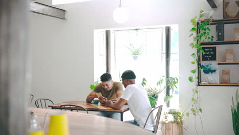 two-young-men-chatting-over-coffee-in-a-coffee