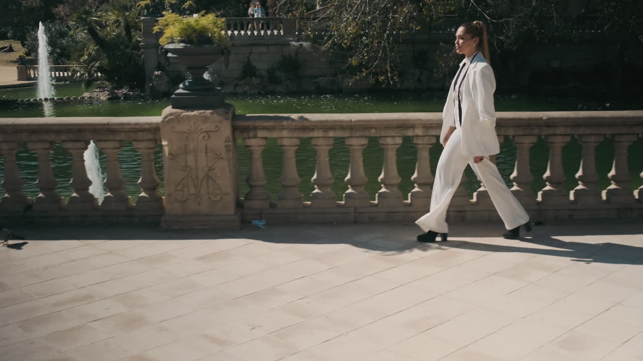 Stylish young woman walking through old park.