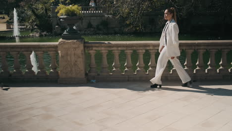 Stylish-young-woman-walking-through-old-park.