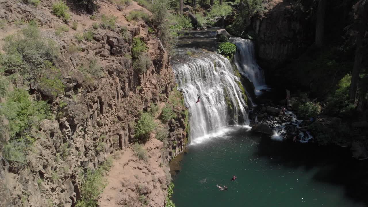 la antena de un dron de proximidad revela un saltador de acantilados en las hermosas cataratas mccloud