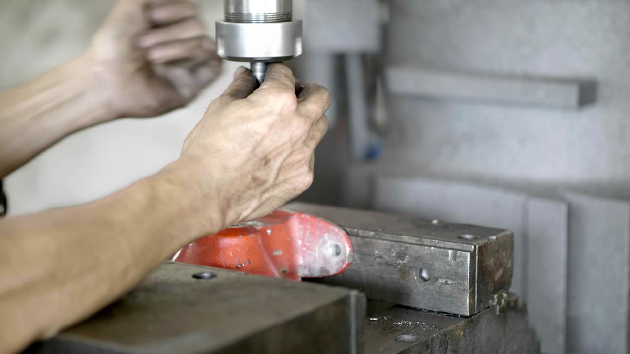 Workers are installing the drill into the machinery in the industrial factory. slow motion