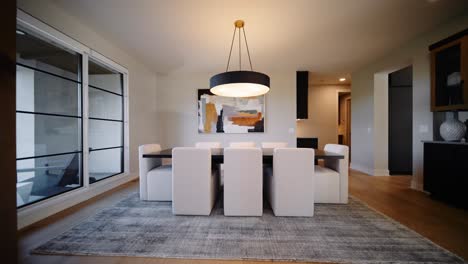 a stylish dining room with a modern table, upholstered chairs, and a contemporary light fixture, complemented by large windows and abstract wall art